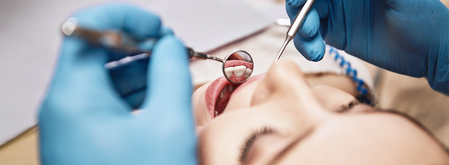 A well-lit reception area with a desk, computer monitor, and potted plant.